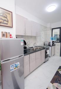 a kitchen with a refrigerator and a sink at Lux Suites Sandalwood Furnished Apartments in Nairobi