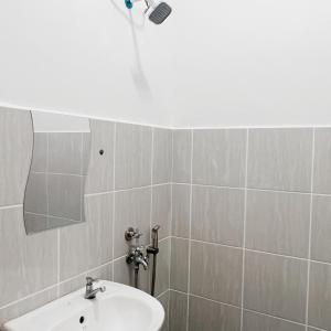 La salle de bains est pourvue d'un lavabo et d'une douche. dans l'établissement Modern Cozy Home with Minimalist design, à Tuaran