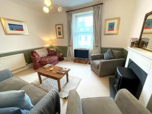 a living room with a couch and a table at Charming 3BR Flat in Beautiful Kirkcudbright in Kirkcudbright