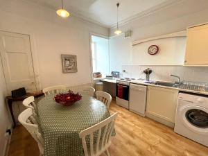 a kitchen with a table with chairs and a sink at Charming 3BR Flat in Beautiful Kirkcudbright in Kirkcudbright