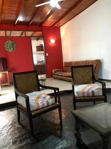 a living room with two chairs and a couch at Casa de Tigres in Tigre
