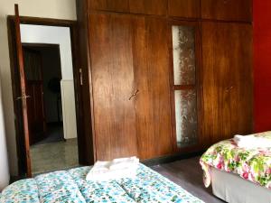 1 dormitorio con 2 camas y puerta de madera en Casa de Tigres en Tigre