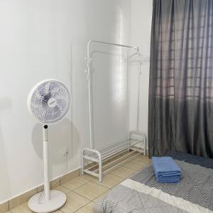 Un ventilador blanco en una habitación con cama en Modern Cozy Home with Minimalist design en Tuaran