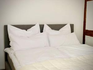 Una cama con sábanas blancas y almohadas. en Beste Lage! Oppenheim, historische Altstadt, en Oppenheim