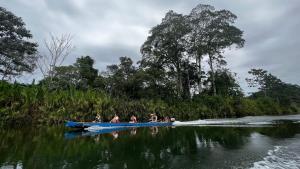 un groupe de personnes dans un bateau bleu sur une rivière dans l'établissement Bribri Eco Aventura, à Talamanca