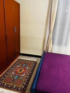een slaapkamer met een paars bed en een tapijt bij Hyfram Homes - Peaceful, Quiet, very fast WI-FI in Kampala