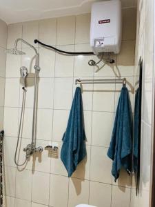 een badkamer met een douche en blauwe handdoeken bij Hyfram Homes - Peaceful, Quiet, very fast WI-FI in Kampala