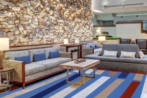 eine Lobby mit Sofas und einer Steinmauer in der Unterkunft Marriott Lexington Griffin Gate Golf Resort & Spa in Lexington