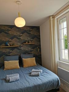 1 dormitorio con 1 cama azul y 2 almohadas en Le Prat - Santec en Santec