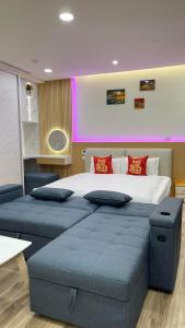 een slaapkamer met een groot bed met twee blauwe poeven bij 宜蘭頭城鎮 Alice 高級溫泉雙-四人套房海景度假 in Hsin-hsing