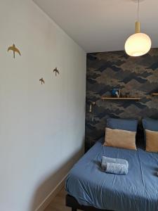 a bedroom with a blue bed with a camouflage wall at Le Prat - Santec in Santec