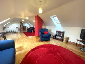 a living room with a red rug and blue chairs at Beautiful Rural 3BR Cottage with Stunning Views in Auldgirth