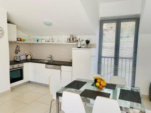 a kitchen with a glass table and white cabinets at Lavender Bay Apartment C31 in Kotor