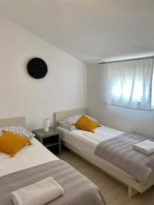 two beds in a small room with a window at Apartments Ivana in Zubovići