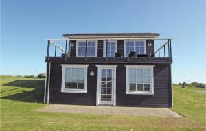 a black house with windows on top of a field at Holiday Home Bagenkop With Fireplace 05 in Bagenkop