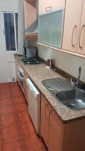 a small kitchen with a sink and a stove at Kaz Bedrooms in Málaga