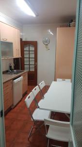 a kitchen with a table and a white table and chairs at Kaz Bedrooms in Málaga