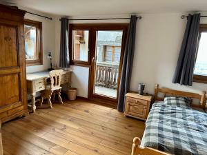 een slaapkamer met een bed, een bureau en een raam bij Gîte des vignes in Bremis