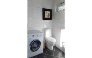 Un baño con lavadora y un inodoro. en Two-Bedroom Apartment In Strandvik, en Dalland
