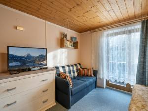 a living room with a blue couch and a tv at Haus Spertental in Kirchberg in Tirol