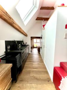 an attic kitchen with a skylight and red furniture at Schönster Blick auf Oppenheim! in Oppenheim