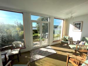 a living room with large windows and a view of the water at Beautiful 4BR Period Home With Spectacular Views in Kippford