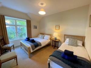 1 dormitorio con 2 camas, silla y ventana en Beautiful 4BR Period Home With Spectacular Views, en Kippford