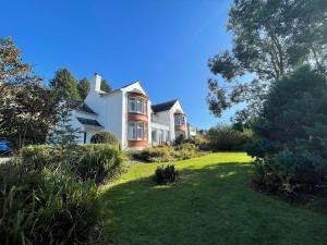 una gran casa blanca con un patio de césped en Beautiful 4BR Period Home With Spectacular Views, en Kippford