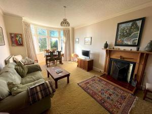 sala de estar con sofá y chimenea en Beautiful 4BR Period Home With Spectacular Views, en Kippford