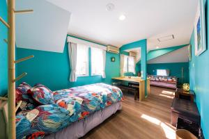 スイートヴィラ清里森テラス美雲 في Kunizakai: غرفة نوم بجدران زرقاء وسرير ومكتب
