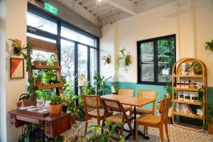 um quarto com mesa, cadeiras e plantas em Lixia Hostel em Xiaoliuqiu