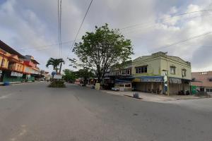 an empty street in a town with a building at OYO 92261 Aulia Homestay Syariah in Bagam