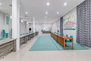 una sala de conferencias con una mesa larga y sillas en Capital O 92250 Hall & Guesthouse Kowapi Syariah, en Purwokerto