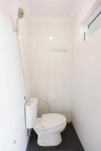 a white bathroom with a toilet in a room at OYO 92261 Aulia Homestay Syariah in Bagam