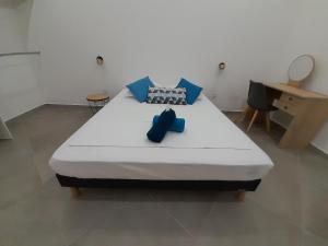 a bedroom with a large bed with blue pillows at Irfanell in Saint-Louis