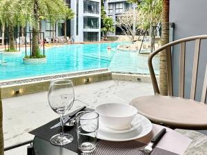 a table with a bowl and wine glasses and a pool at Kamala Beach Pool view Resort P15 in Kamala Beach