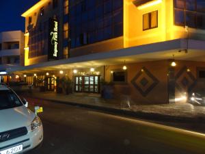 a white car parked in front of a building at night at Regency Park Hotel in Mombasa