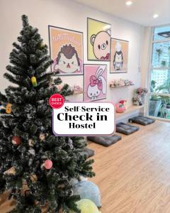 a christmas tree in a living room with a self service check in house at CuteinNan Hostel in Nan