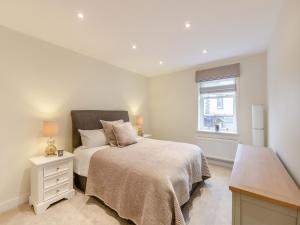 a white bedroom with a bed and a window at Market Square in Grassington