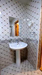 ein Bad mit einem Waschbecken und einem Spiegel in der Unterkunft Hotel Shaherezade Garden in Buxoro