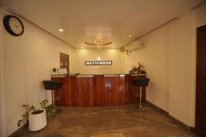 a lobby with a reception desk and a clock on the wall at Mayookham in Thirunelli