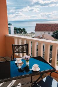 a table on a balcony with a view of the ocean at Apartman PETRA in Trogir