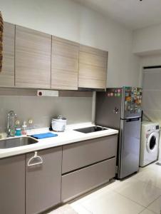 a kitchen with a sink and a refrigerator at RDR Homestay@Emira Residence in Shah Alam
