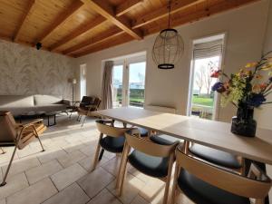 een woonkamer met een tafel en stoelen bij De Sloothaak in Giethoorn