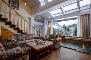 a living room with couches and a table at Baan by Snow City Farm in Vashisht