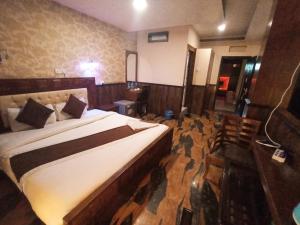 um quarto com uma cama grande num quarto em Hotel Prakash International em Heṭauḍā