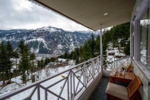 a balcony with a view of a snowy mountain at Baan by Snow City Farm in Vashisht