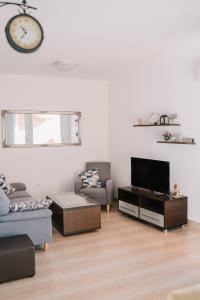 a living room with a clock on the wall at Apartman PETRA in Trogir