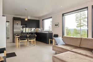 uma sala de estar e cozinha com um sofá e uma mesa em Villa Horihane - Modern Villa with panoramic view em Ivalo