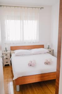 a bedroom with a bed with two pink towels on it at Apartman PETRA in Trogir